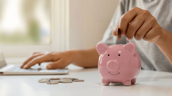 Henkilö vertailee lainatarjouksia kotona ja suunnittelee budjettiaan säästääkseen arjessa